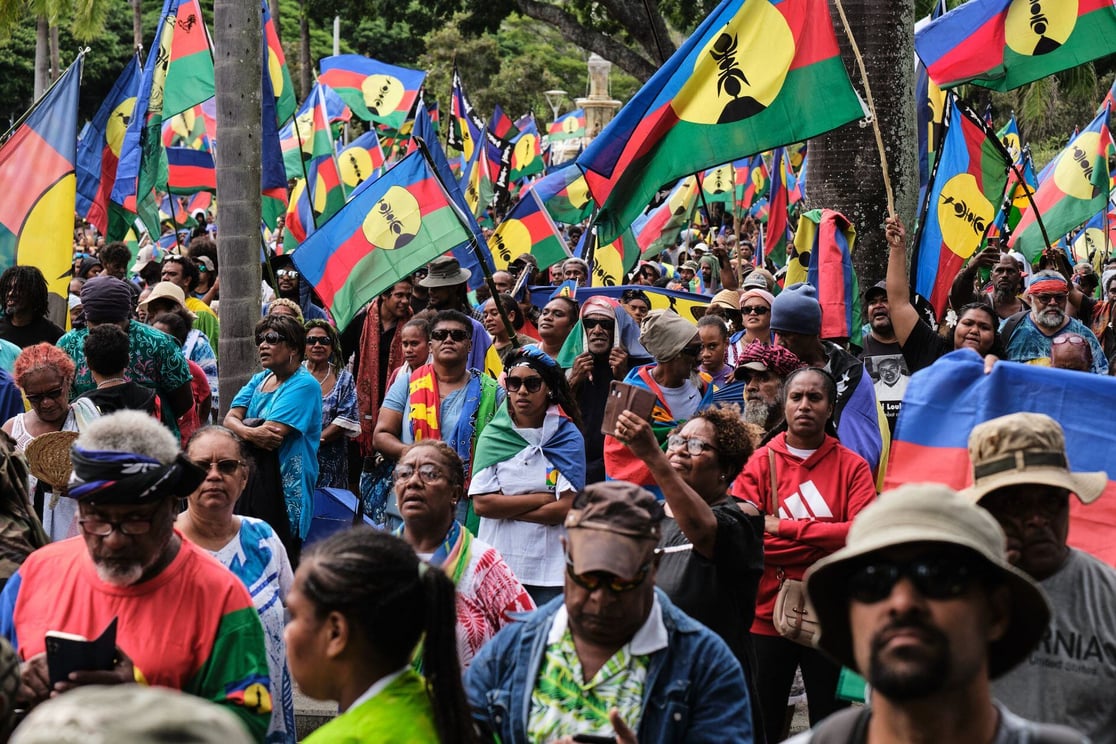 Image of Indigenous Kanak waiving their flags in New Caledonia